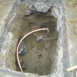 Whole in concrete with a newly installed copper pipe